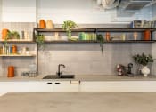 Thumbnail 12 of 35 - a kitchen with white cabinets and shelves and a sink