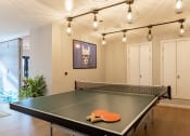 Thumbnail 2 of 15 - a ping pong table in a living room with lights on
