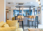Thumbnail 4 of 15 - a living room with a bar and a couch