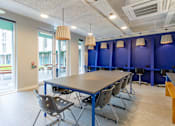 Thumbnail 22 of 51 - A conference room with a long table and chairs.