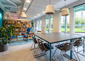 Thumbnail 17 of 51 - A room with a table, chairs, and a bookshelf.