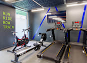 Thumbnail 29 of 51 - A treadmill and a stationary bike in a gym.