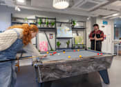 Thumbnail 14 of 51 - A woman playing pool in an office setting.