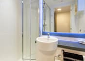 Thumbnail 44 of 51 - A white sink in a bathroom with a glass shower door.