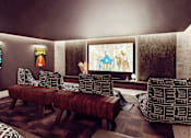 Thumbnail 7 of 17 - A living room with a large screen and a couch.