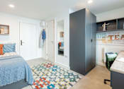 Thumbnail 1 of 35 - A bedroom with a bed, a wardrobe, and a chair.