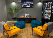 Thumbnail 1 of 13 - a lounge area with yellow chairs and a television