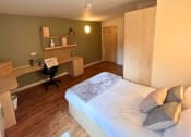 Thumbnail 9 of 13 - a bedroom with a bed and a desk
