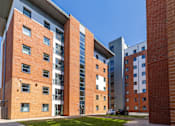 Thumbnail 1 of 35 - A red brick building with a white car parked in front.