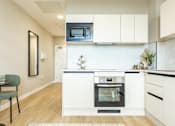 Thumbnail 61 of 64 - A modern kitchen with white cabinets and a black oven.