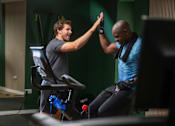 Thumbnail 51 of 85 - A man in a black shirt is giving a high five to another man in a blue shirt.