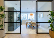 Thumbnail 39 of 64 - A modern dining room with a glass door entrance.
