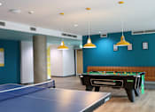 Thumbnail 1 of 21 - A pool table is in the middle of a room with a ping pong table in front of it.