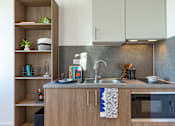 Thumbnail 17 of 29 - A modern kitchen with a wooden counter and a grey backsplash.