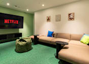 Thumbnail 9 of 29 - A Netflix sign is on a wall above a couch.