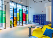 Thumbnail 14 of 29 - A brightly colored interior with a yellow sofa and a table with a blue and white cushion.