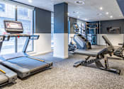 Thumbnail 7 of 29 - A gym with treadmills, weights, and a television.