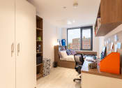Thumbnail 26 of 29 - a home office with a desk and a couch in a window