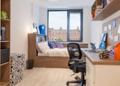 Thumbnail 18 of 29 - a bedroom with a bed and a desk in a small room
