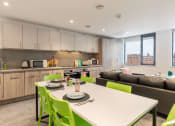 Thumbnail 21 of 29 - a kitchen and living room with a white table and green chairs