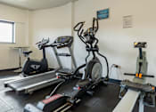 Thumbnail 4 of 30 - A gym with treadmills, elliptical machines, and other exercise equipment.