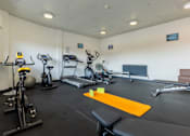 Thumbnail 5 of 30 - A gym with a variety of equipment including treadmills, stationary bikes, and weight machines.