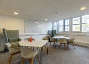 Thumbnail 8 of 13 - a meeting room with tables and chairs and a projection screen