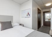 Thumbnail 3 of 13 - a bedroom with a bed and a door to a bathroom