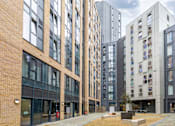 Thumbnail 46 of 49 - A modern building with a mix of brick and glass facades.