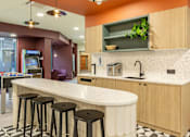 Thumbnail 7 of 49 - A kitchen with a counter and bar stools.