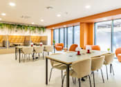Thumbnail 28 of 49 - A conference room with white chairs and a long table.
