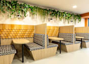 Thumbnail 29 of 49 - A row of wooden chairs with grey patterned cushions are arranged in a row.