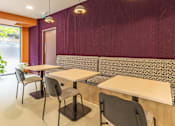 Thumbnail 30 of 49 - A room with a purple wall and a table with chairs.