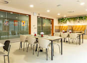 Thumbnail 22 of 49 - A conference room with white tables and chairs.