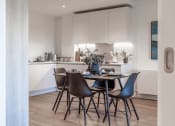 Thumbnail 7 of 37 - a dining area with a table and chairs and a kitchen in the background