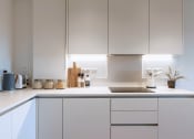 Thumbnail 8 of 37 - a white kitchen with white cabinets and a sink