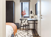 Thumbnail 10 of 37 - a bedroom with a bed and a desk with a chair and a window