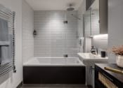 Thumbnail 15 of 37 - a small white bathroom with a tub and a sink