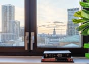 Thumbnail 24 of 37 - a view of the city from a window with a stack of books