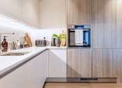 Thumbnail 18 of 37 - a kitchen with white cabinets and an oven and a sink