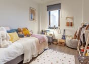 Thumbnail 20 of 37 - a bedroom with a bed with yellow and white pillows and a window
