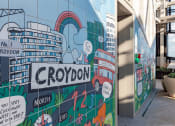 Thumbnail 35 of 37 - a mural on the side of a building with buildings and a rainbow