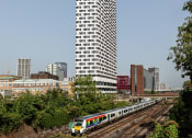 Thumbnail 37 of 37 - a train on the tracks in front of a tall building
