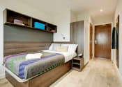 Thumbnail 6 of 39 - a bedroom with a bed and a wooden door