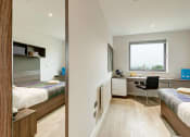 Thumbnail 7 of 39 - a bedroom with a bed and a desk in a room