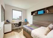 Thumbnail 9 of 39 - a bedroom with a bed and desk in a 555 waverly unit