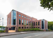 Thumbnail 38 of 39 - a large brick building with a road in front of it