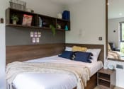 Thumbnail 26 of 39 - a bedroom with a bed and a mirror