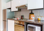 Thumbnail 29 of 39 - a kitchen with white cabinets and a white microwave oven