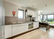 Thumbnail 12 of 39 - a kitchen with white cabinets and a wooden floor